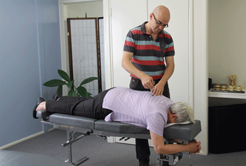 Our Chiropractor Dr David Malone using the Activator to adjust a client